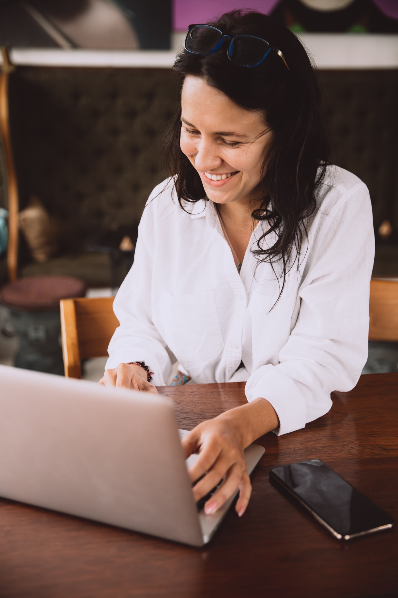 Beautiful woman in glasses making video call by laptop, working remotely